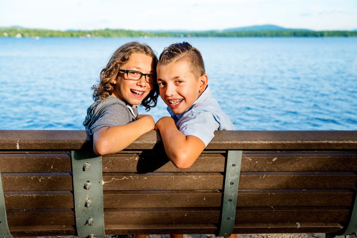 Two happy kids smiling while wearing their braces on family vacation